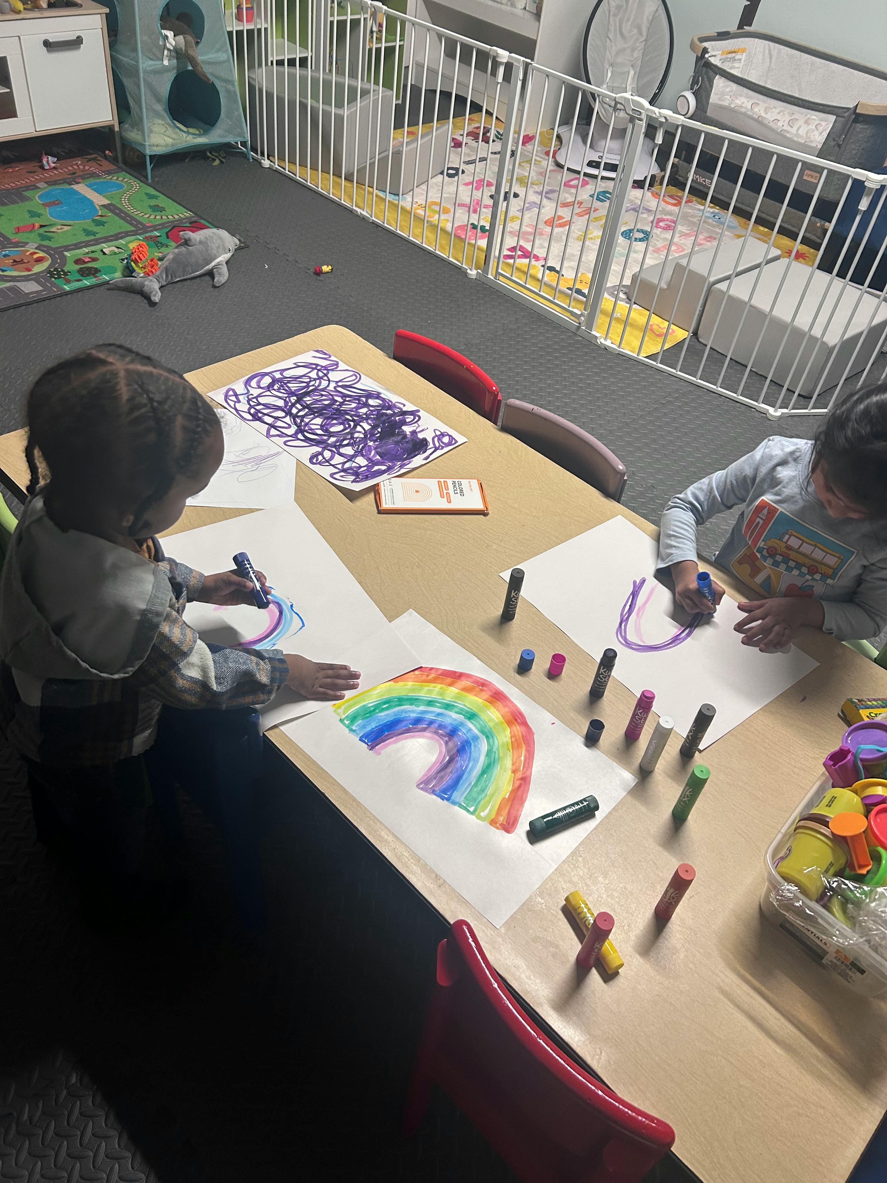 Two children drawing at a table