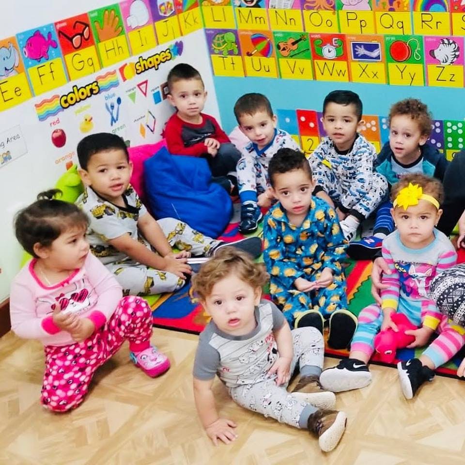 Group of children sitting on the floor in a classroom