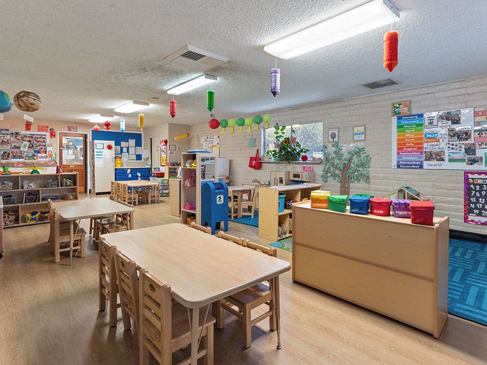 Empty classroom with small tables and chairs, and colorful decorations