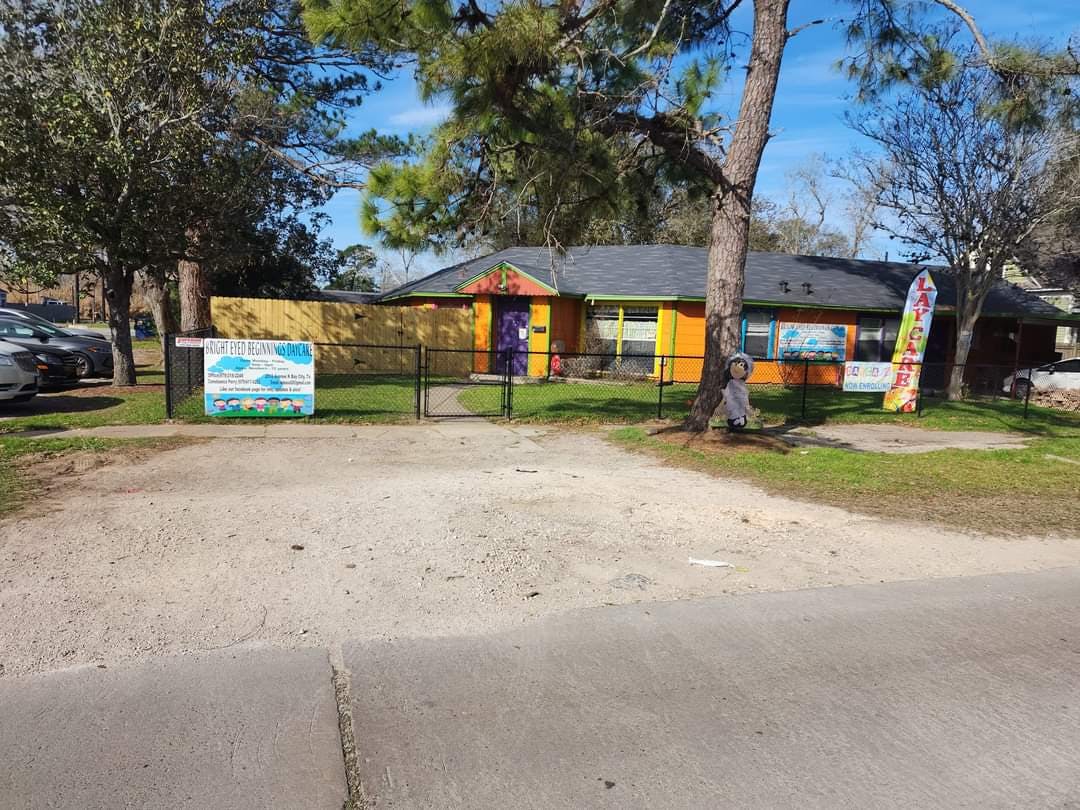 Orange house with a black fence and a sign in front