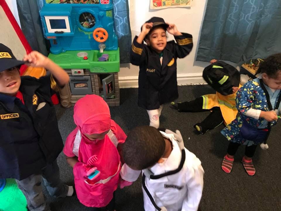 Children in various costumes playing in a room