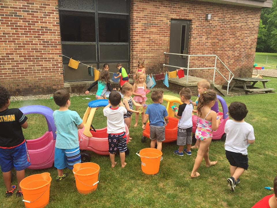 Children playing with water and buckets outdoors