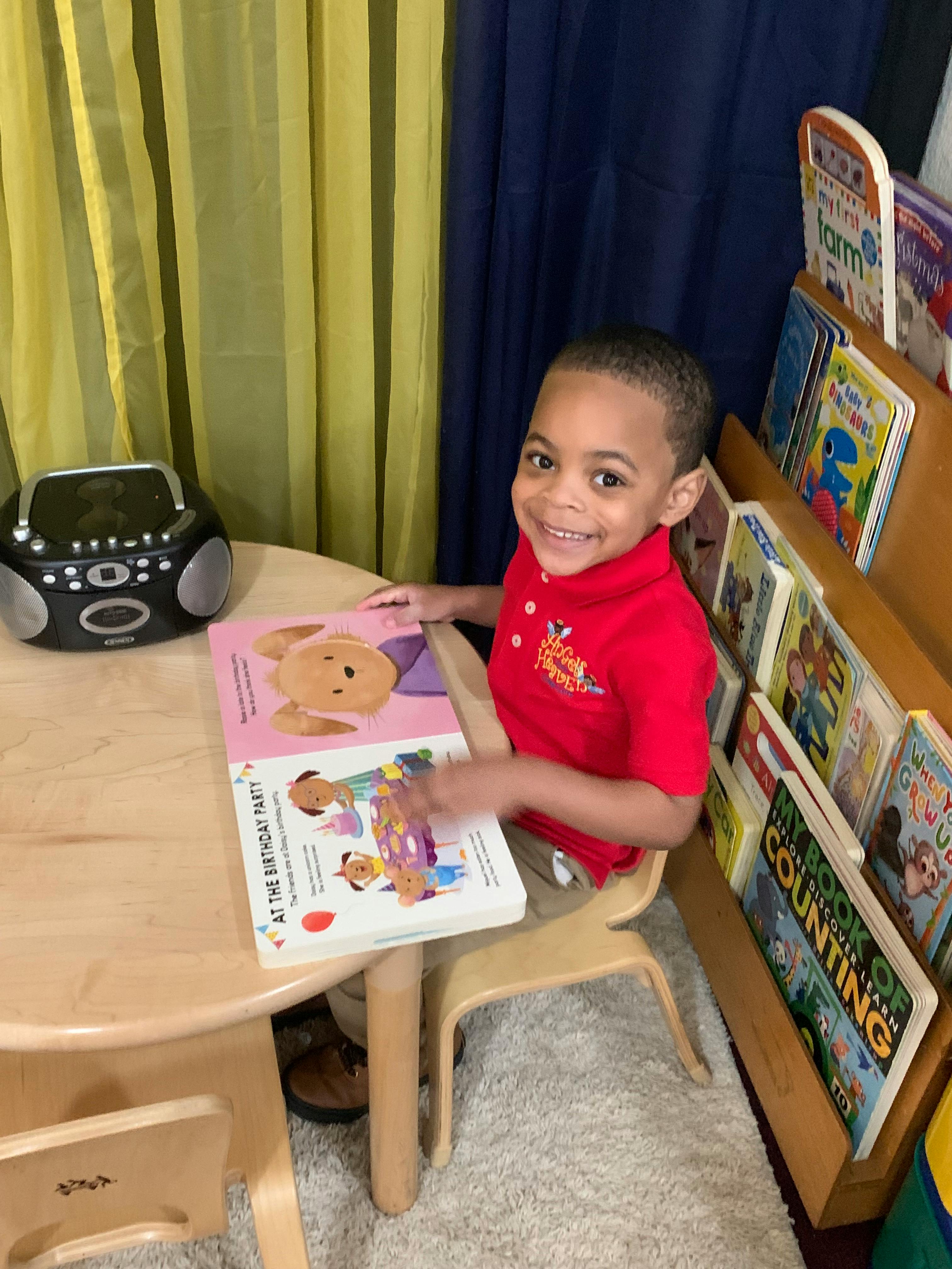Child sitting at a table with an open book
