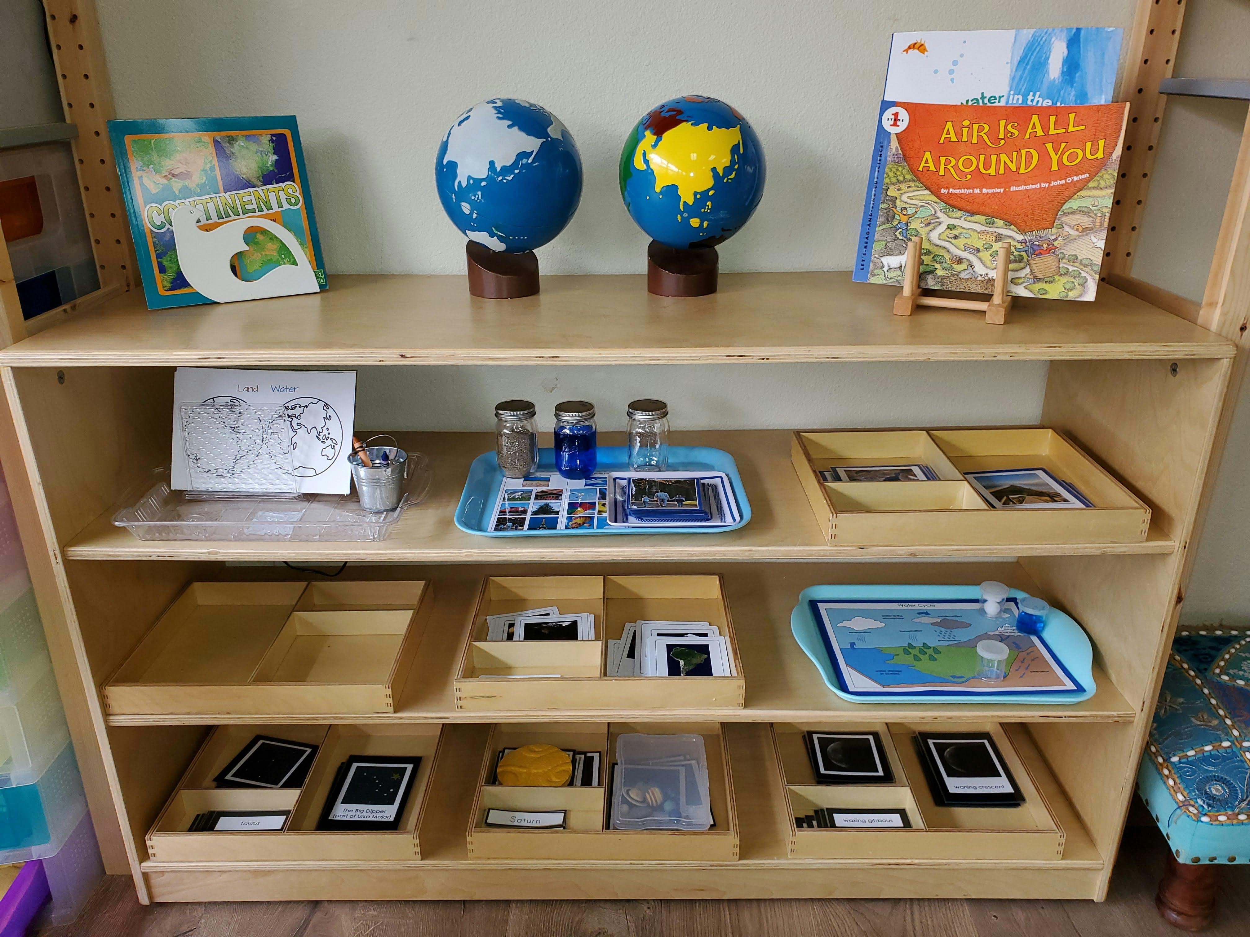 Montessori classroom shelving unit with globes, books, and learning materials