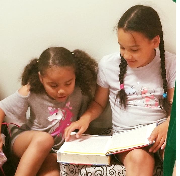 Two children reading a book together