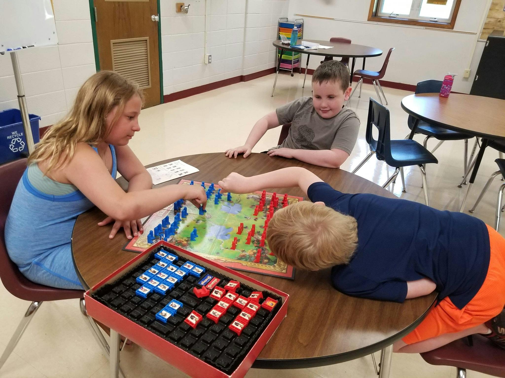 Three children playing a board game at a table
