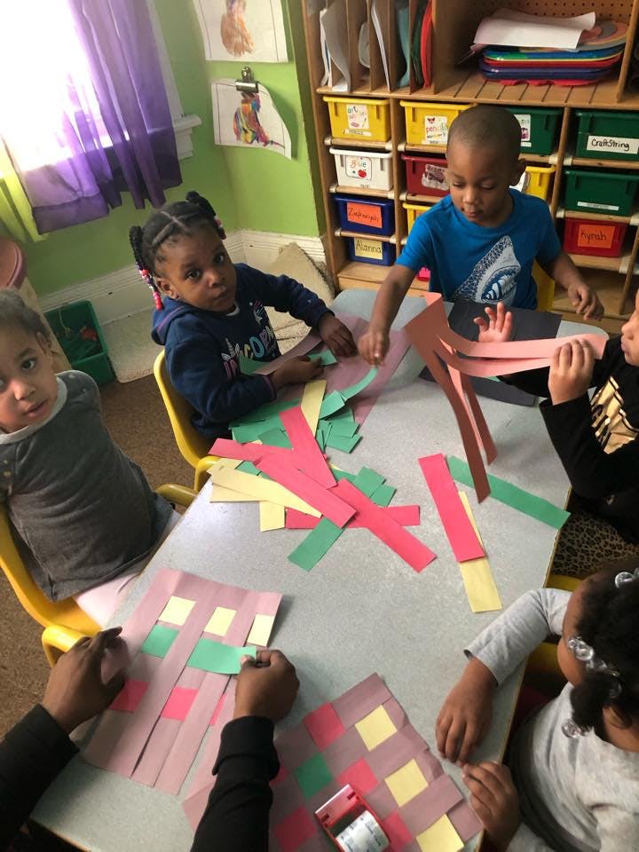 Children at a table doing a paper craft activity