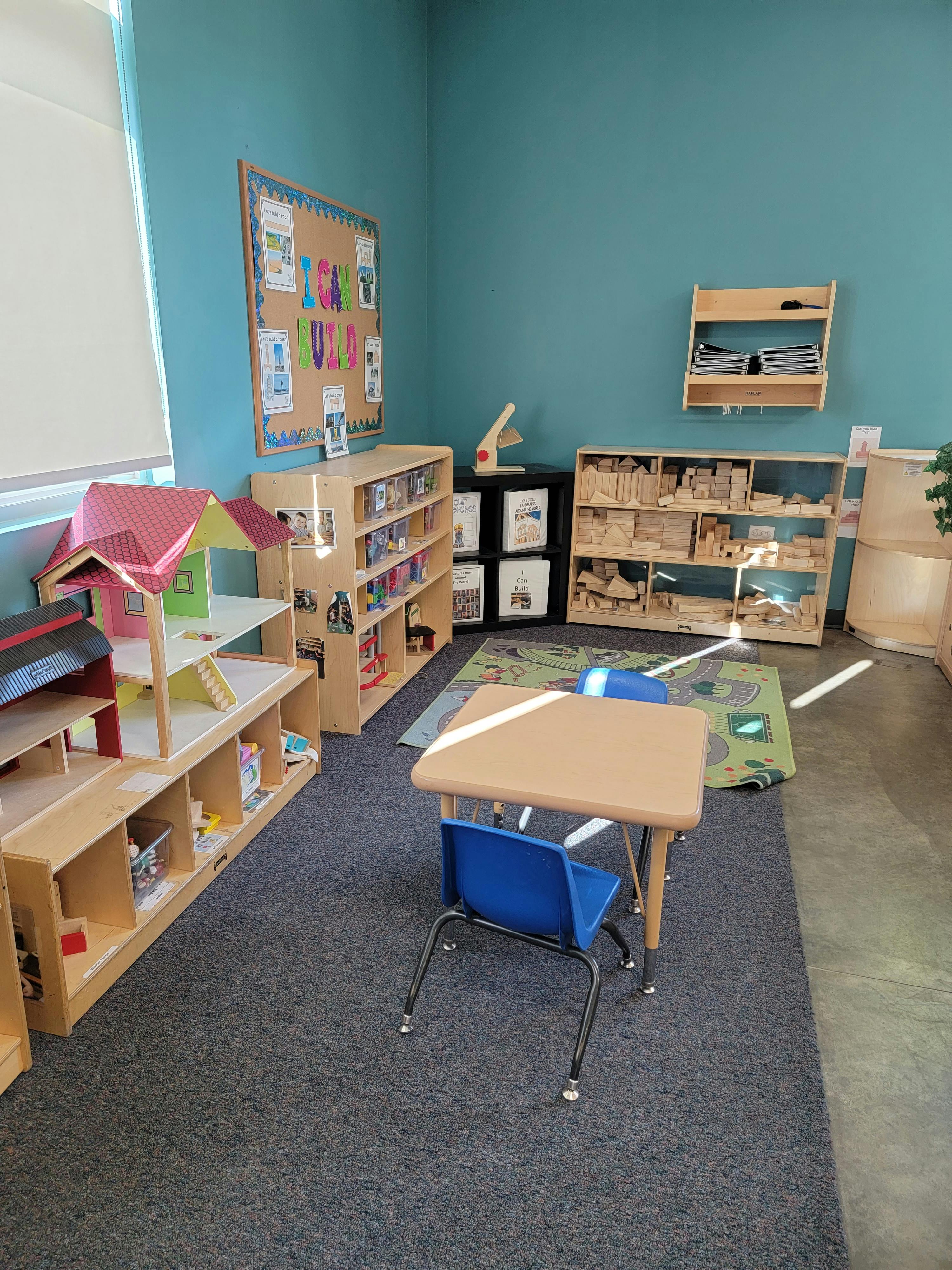 Classroom with shelves of toys and books, a small table and chair