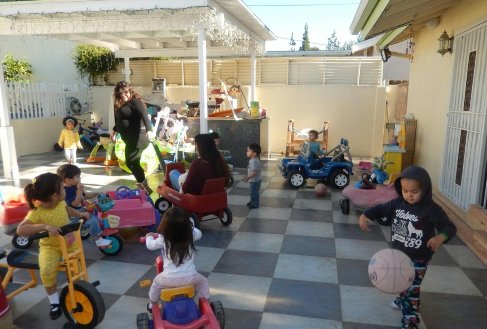 Adults and children playing with toys in an outdoor area
