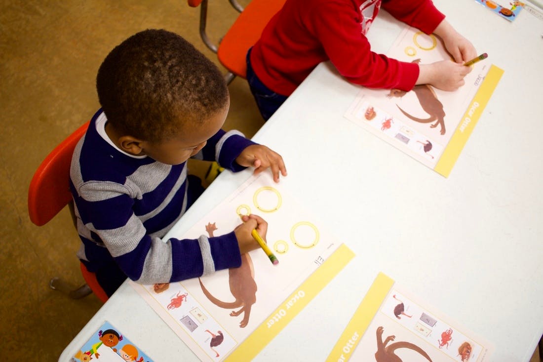 Two children drawing at a table