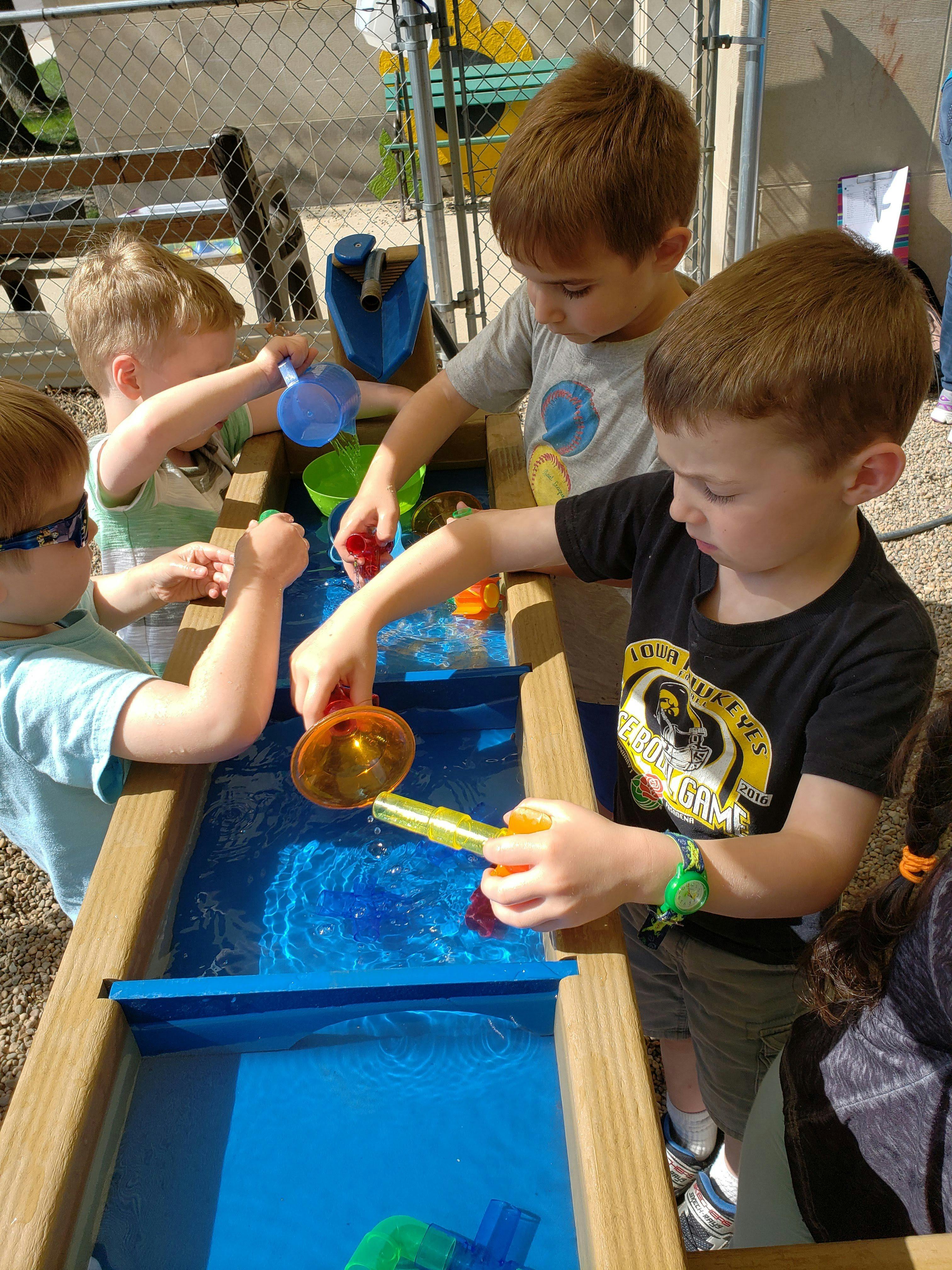 Children playing with water in a water table