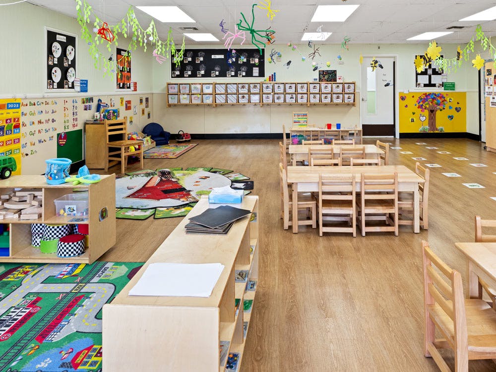 empty preschool classroom with small tables and chairs
