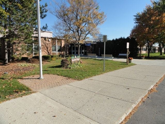Building exterior with a sidewalk and grassy area in front