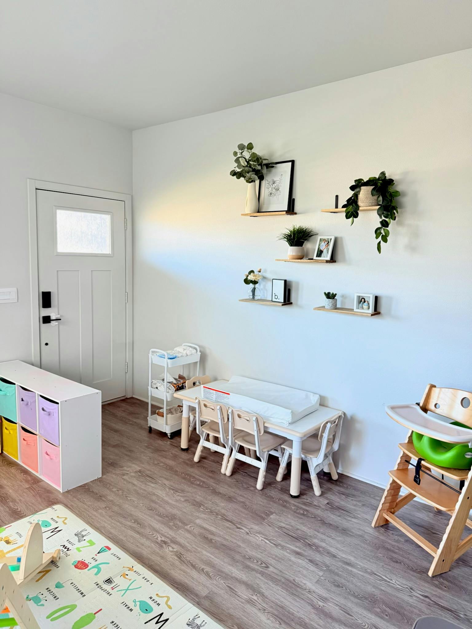 Child's play area with small table and chairs, storage, and high chair