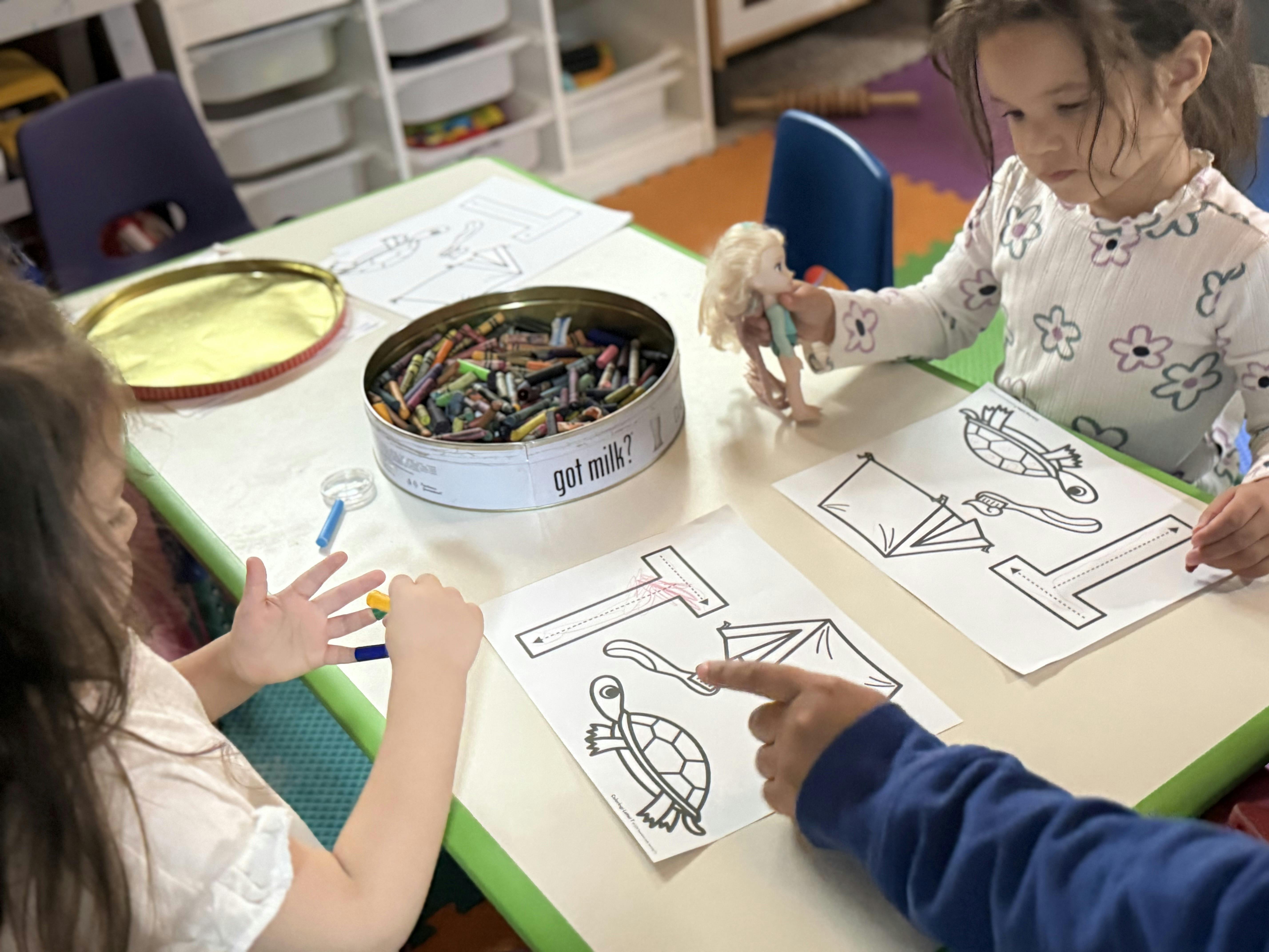 People using coloring sheets and crayons at a table