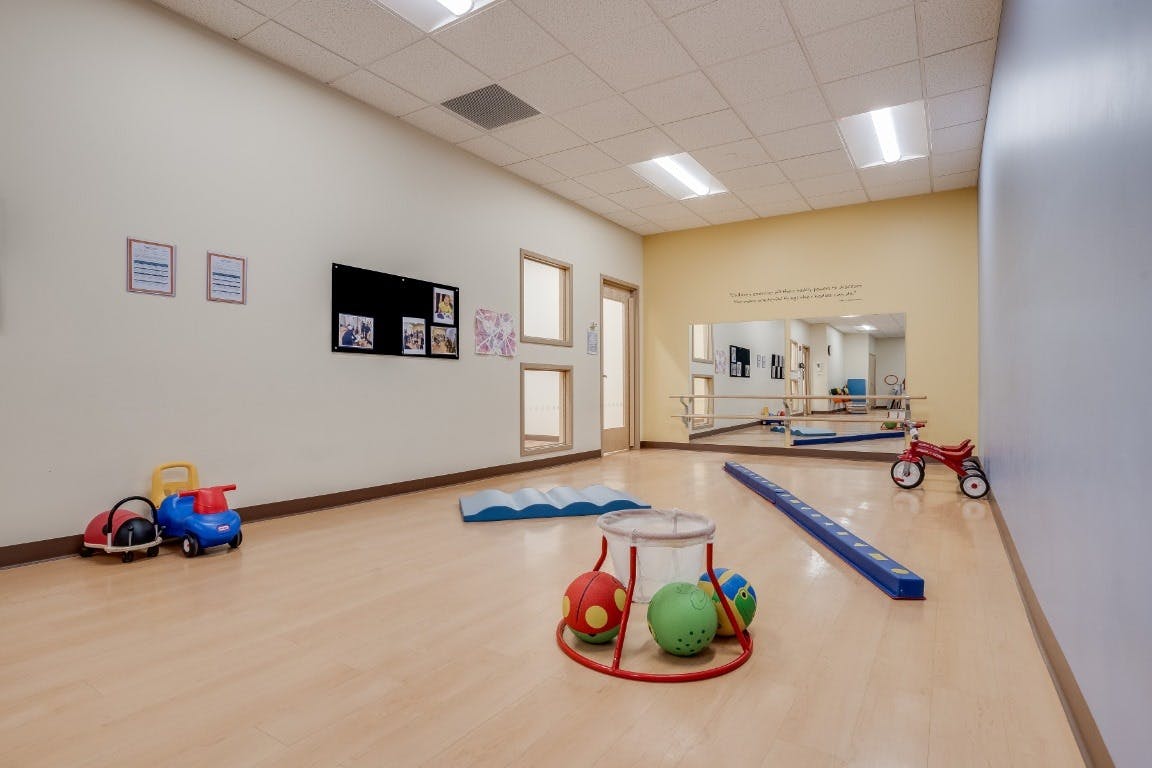 Playroom with ride-on toys, balls, and a balance beam