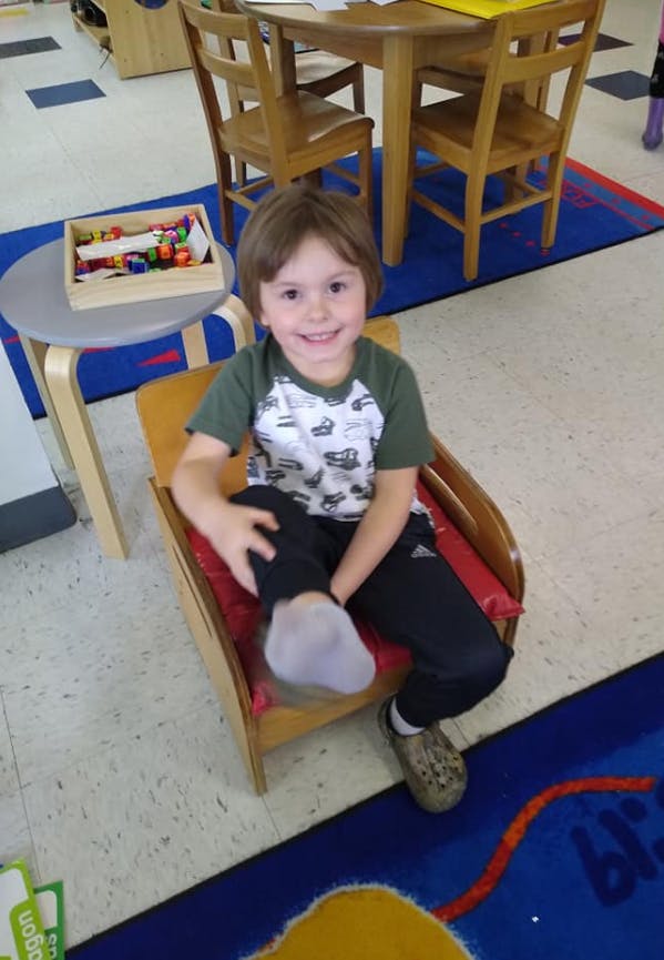 Child sitting in a chair in a classroom