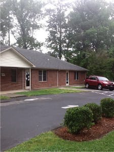 Brick building with a red car parked outside