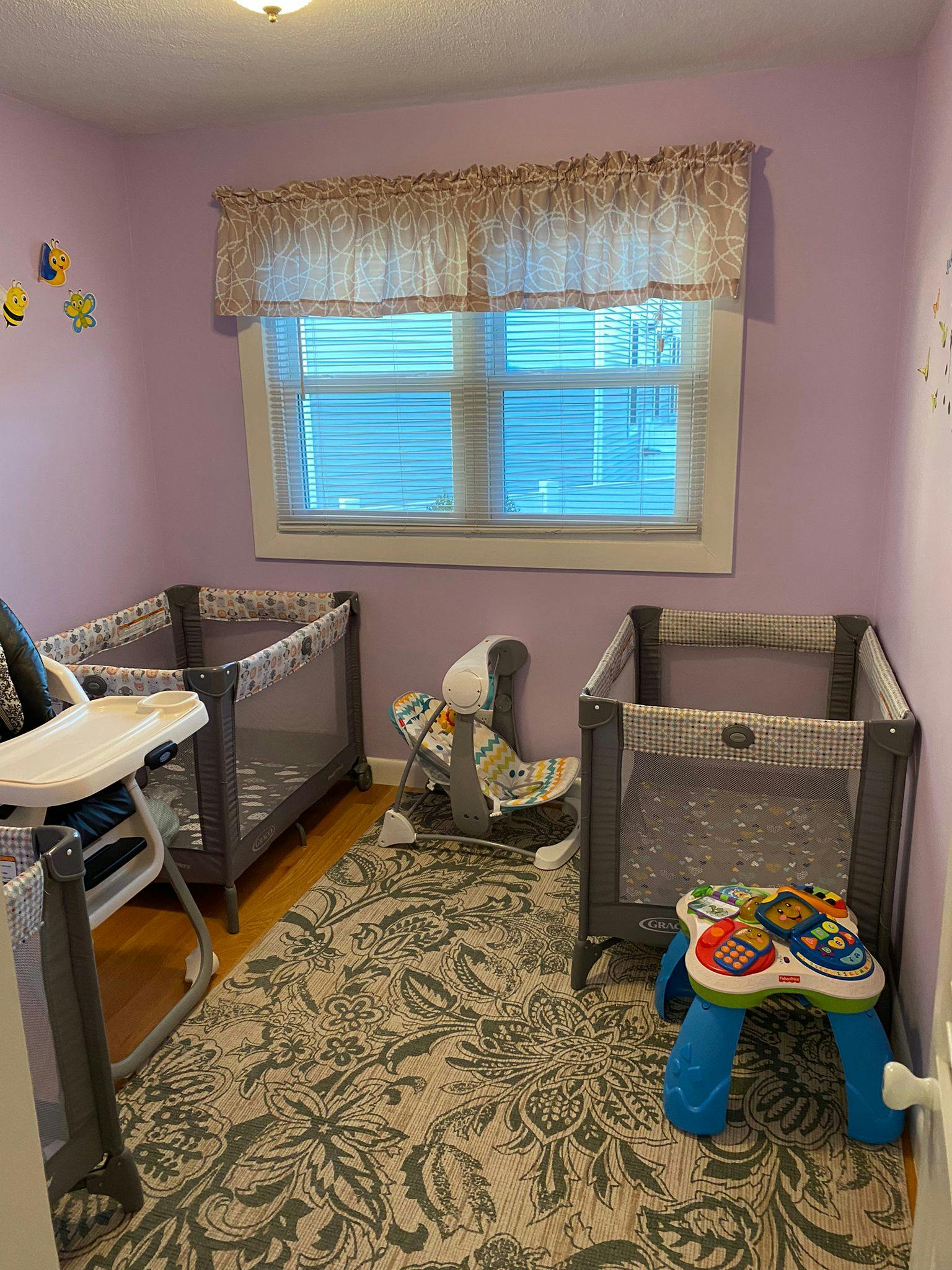 Two playards and a high chair in a room