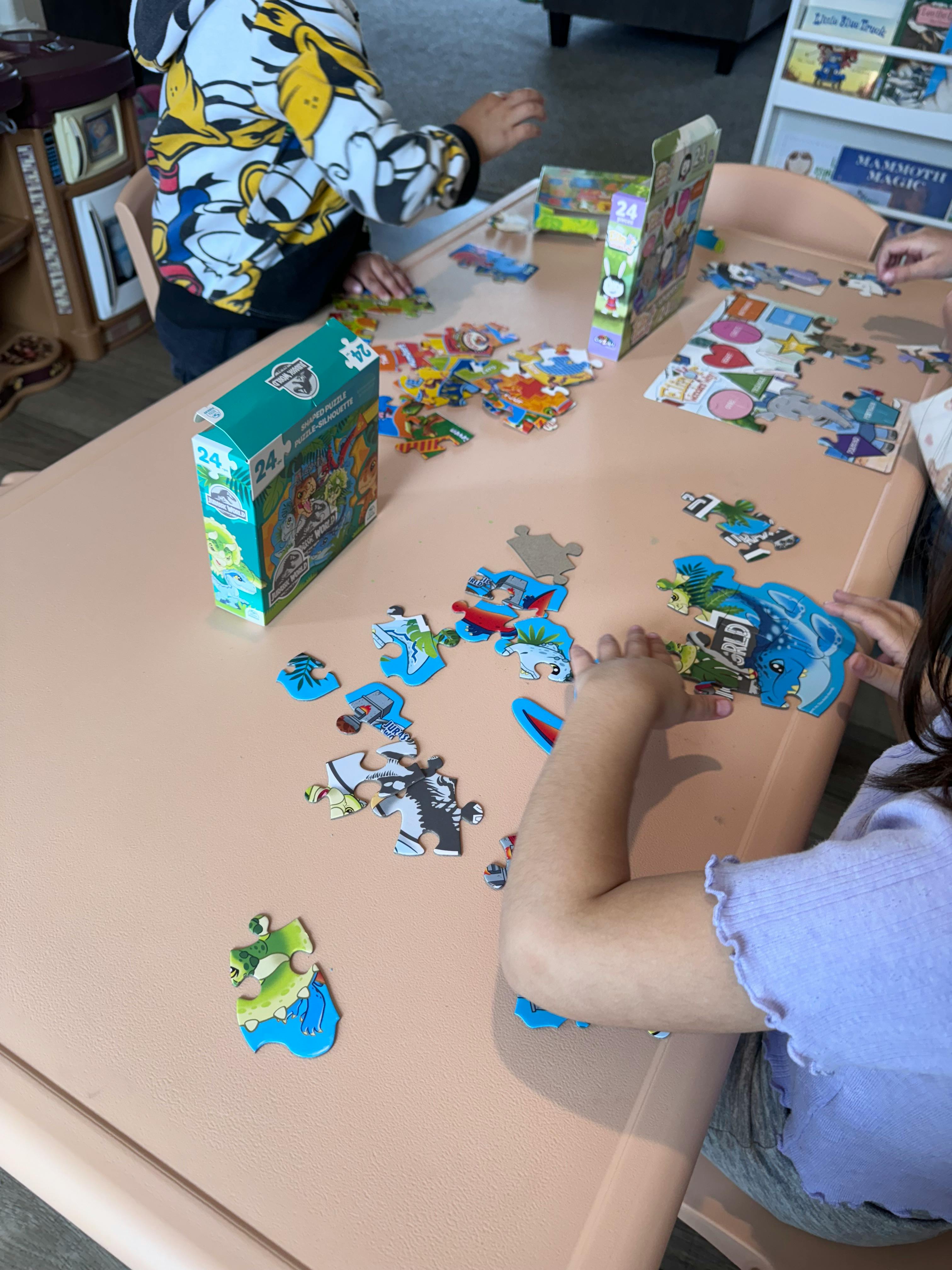 Children assembling puzzles on a table