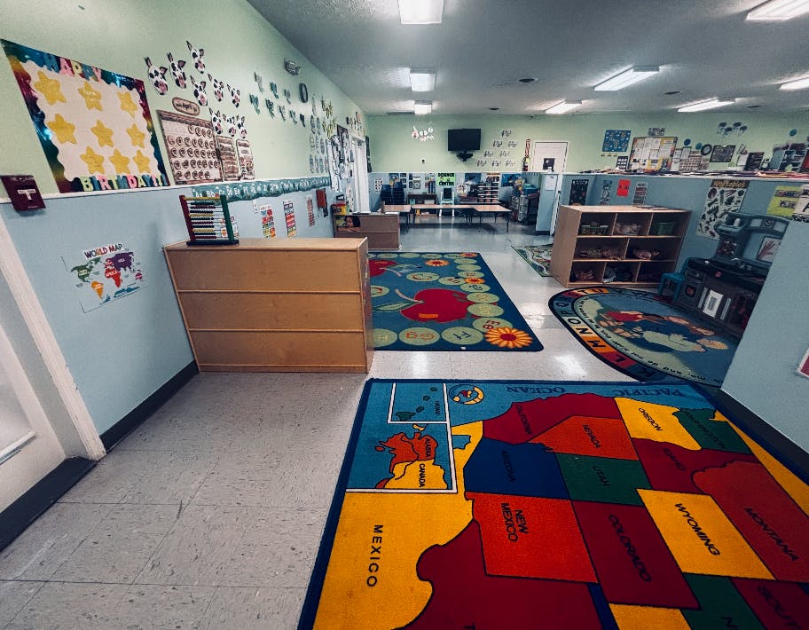 Colorful rugs and educational displays in an empty preschool classroom