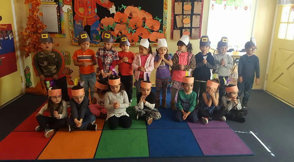 Group of children wearing hats in a classroom