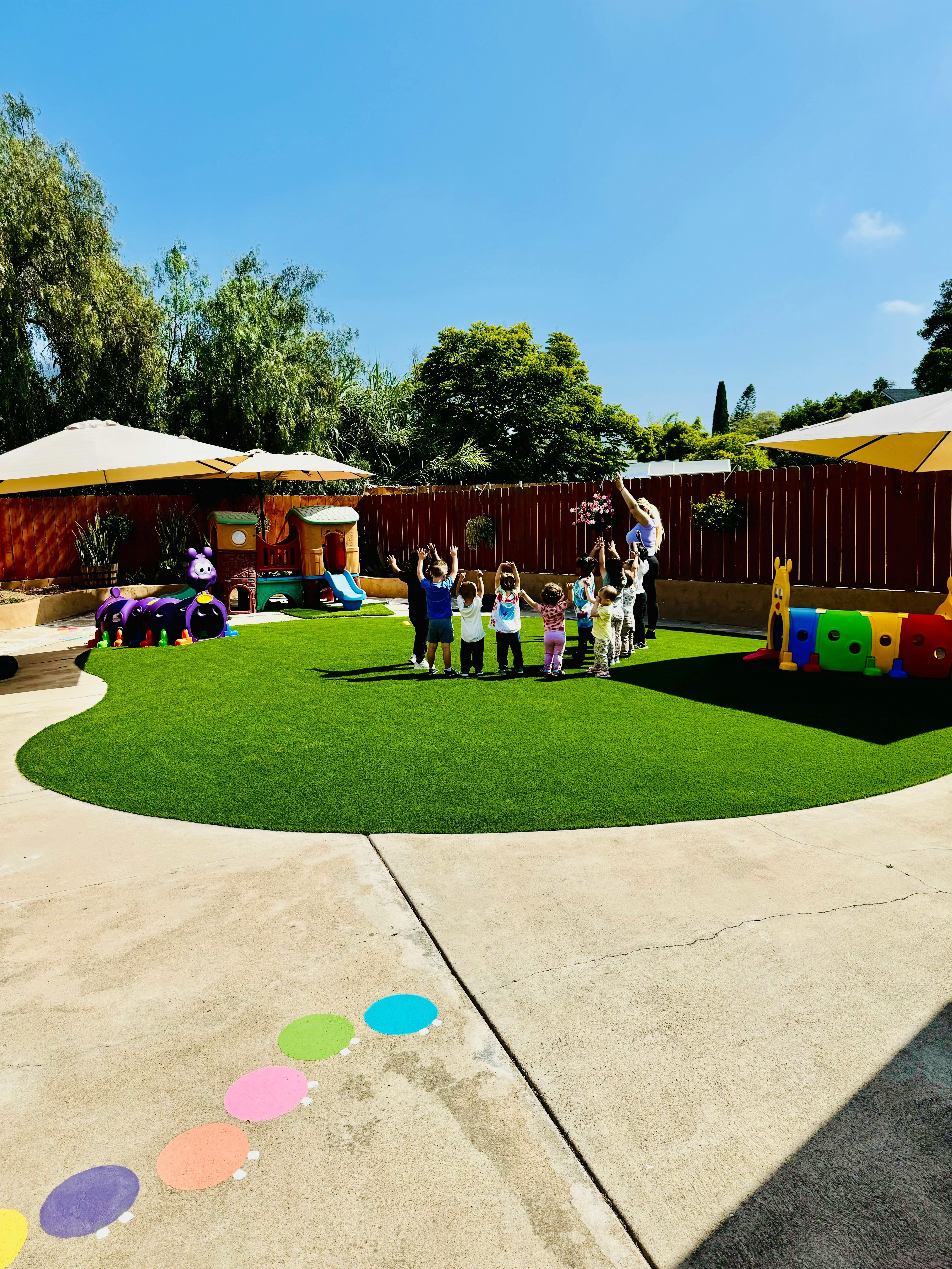 Children and adults on a playground with artificial grass