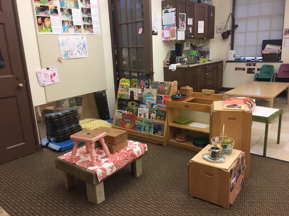 Classroom with small tables, chairs, and bookshelves