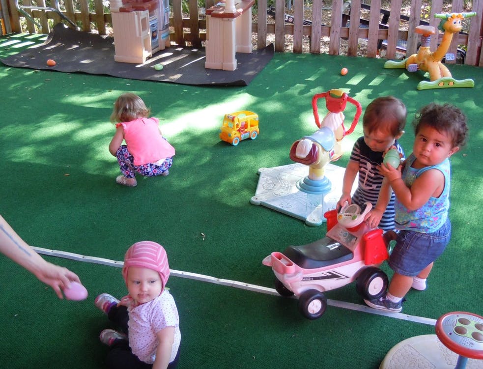 Children playing with toys on a green surface