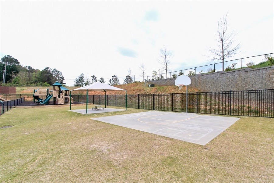 Outdoor recreation area with playground, picnic shelter, and basketball court