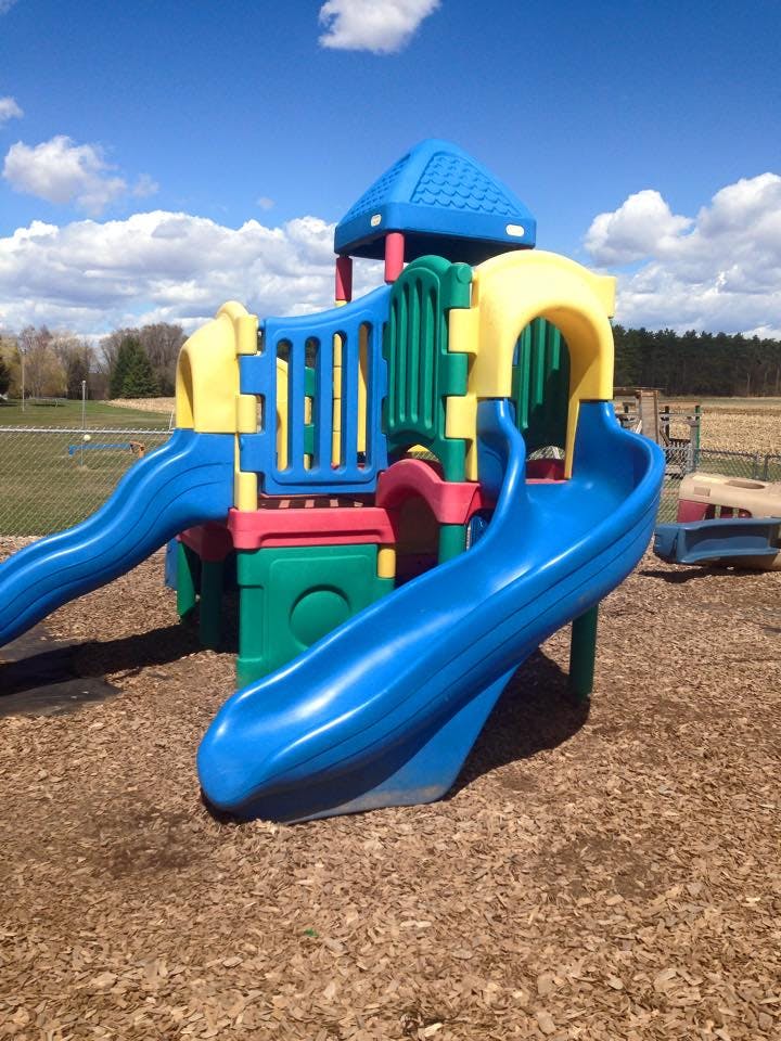 Colorful playground structure with slides on wood chips