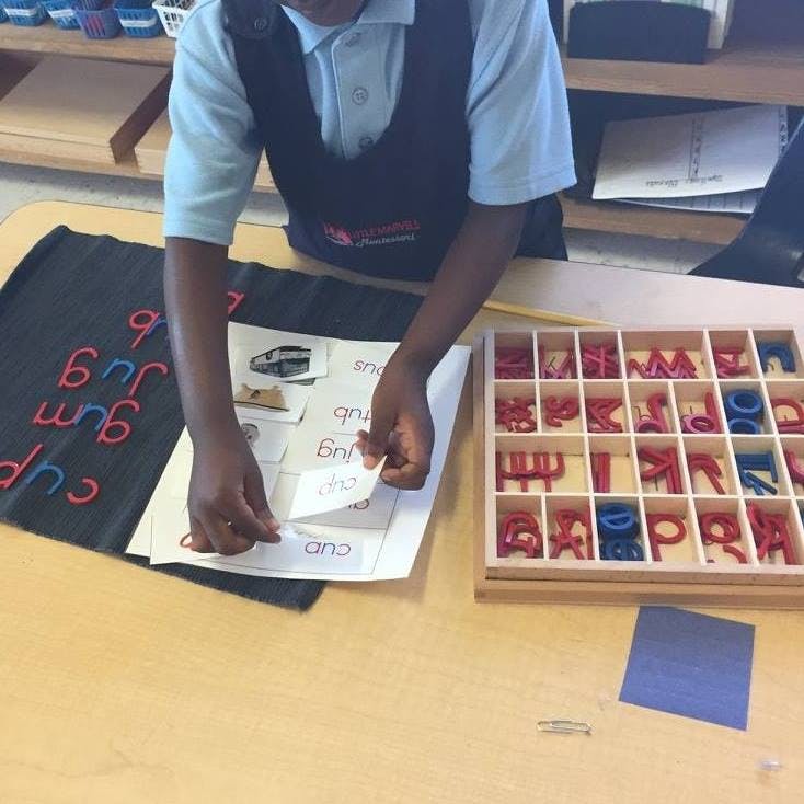 Child working with letter tiles and word cards