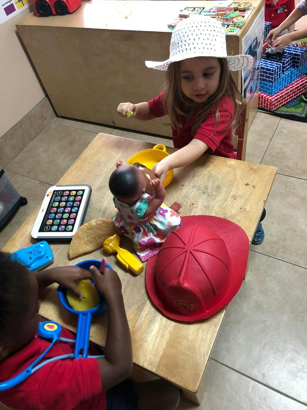 Two children playing with toys at a table
