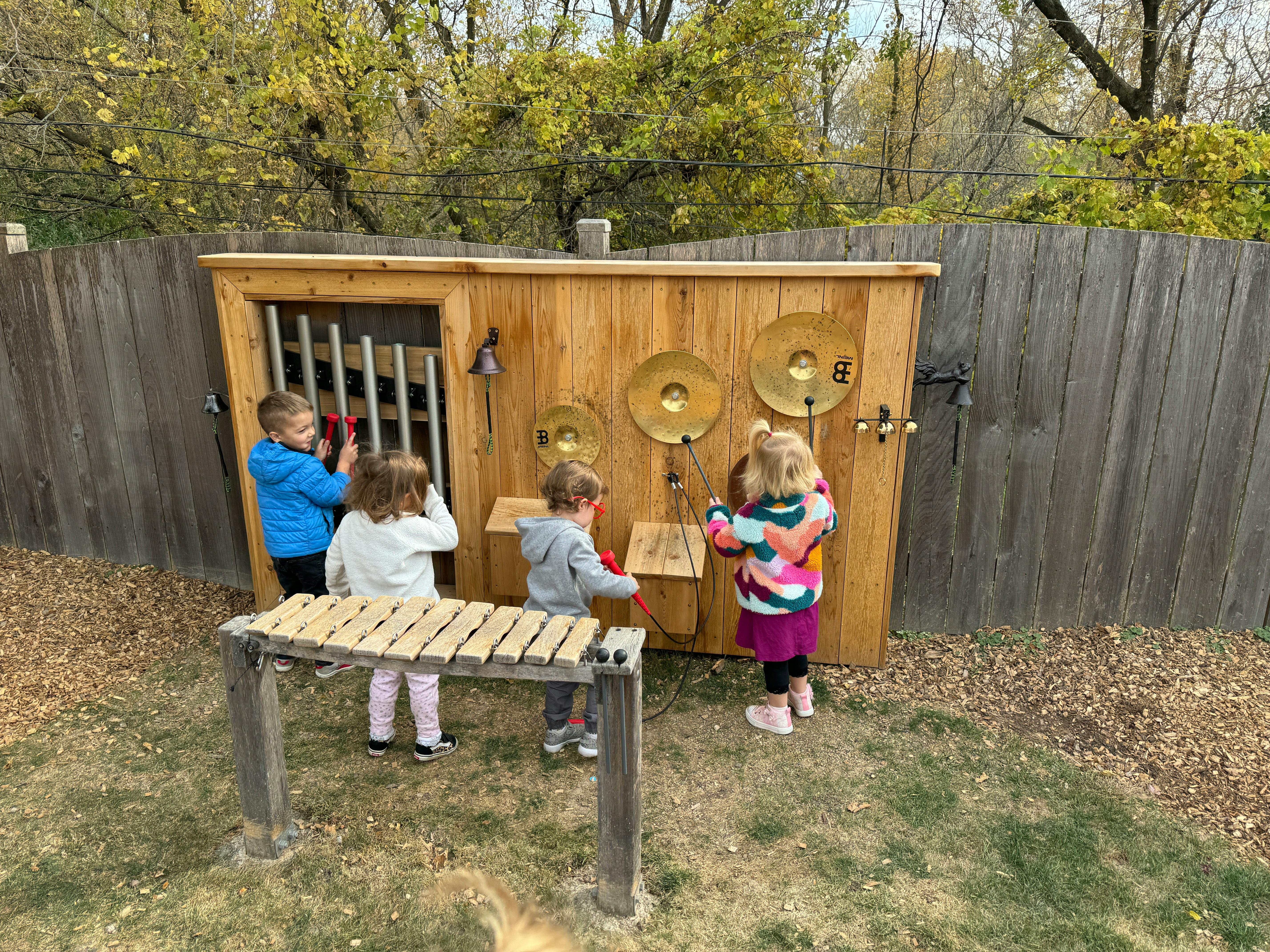 Children playing with outdoor musical instruments