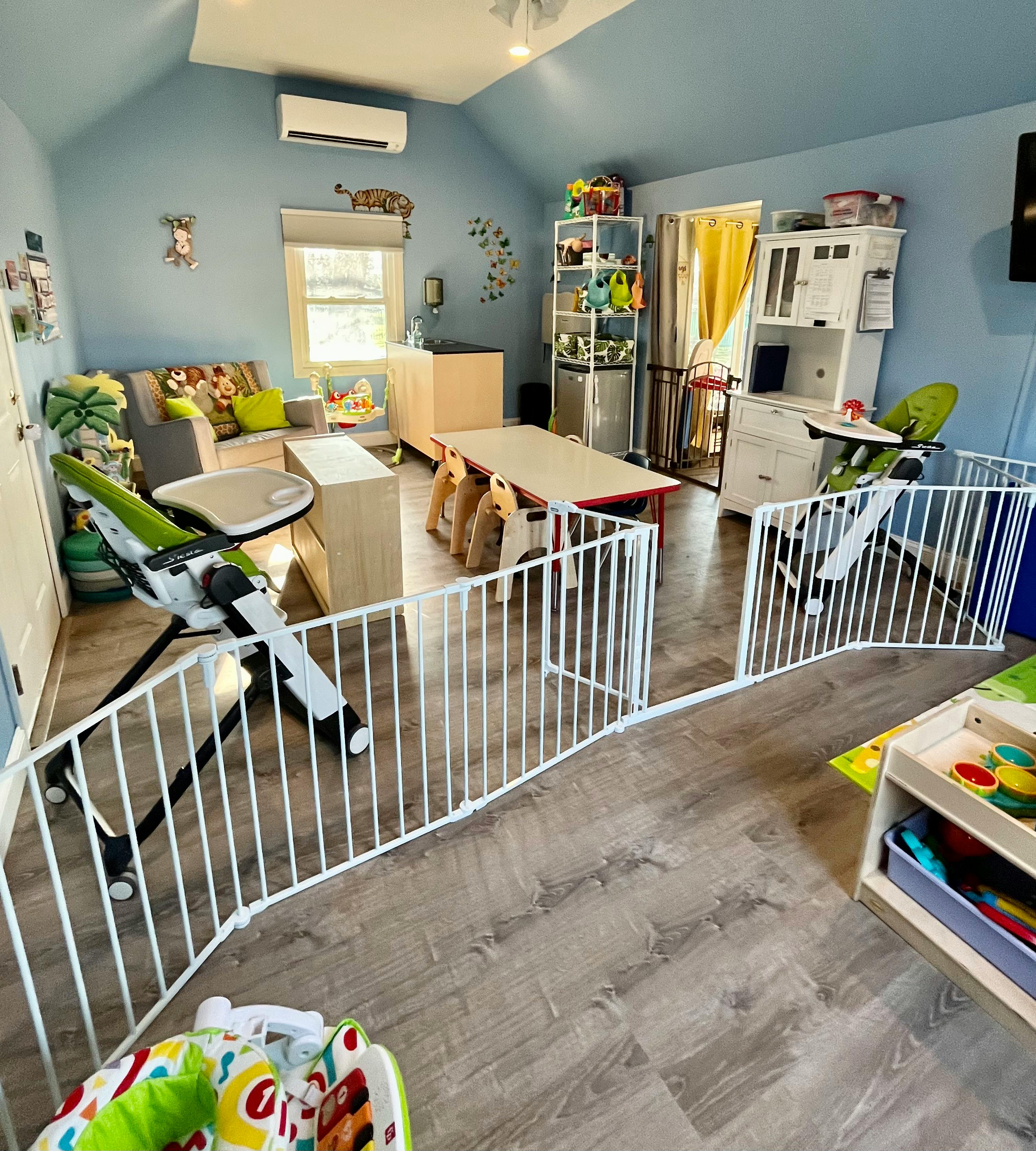 Playroom with baby gates, high chairs, and small tables