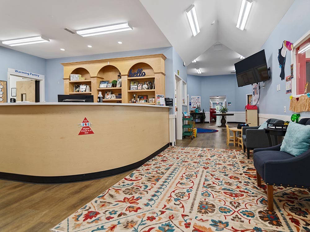 Reception desk with a 'Digital Check In & Out' sign, and a waiting area
