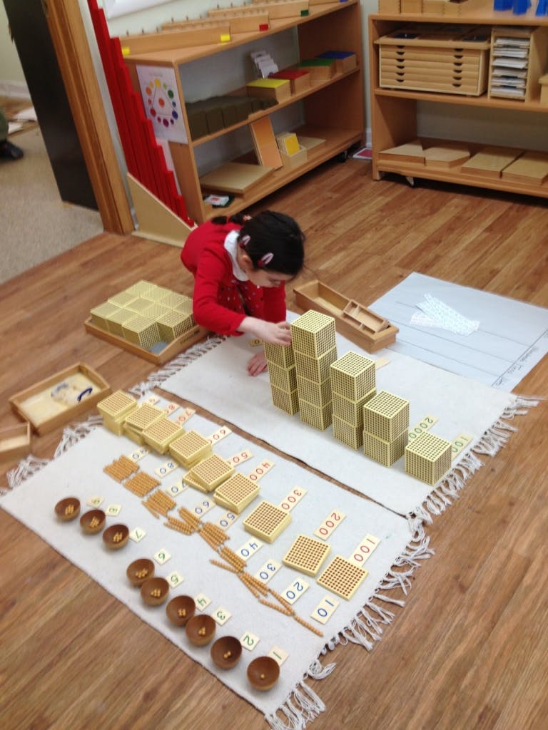 Child playing with blocks and learning materials on a rug