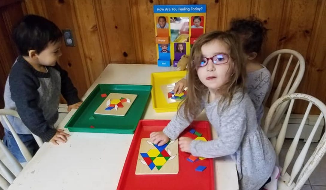 Children playing with shape puzzles at a table