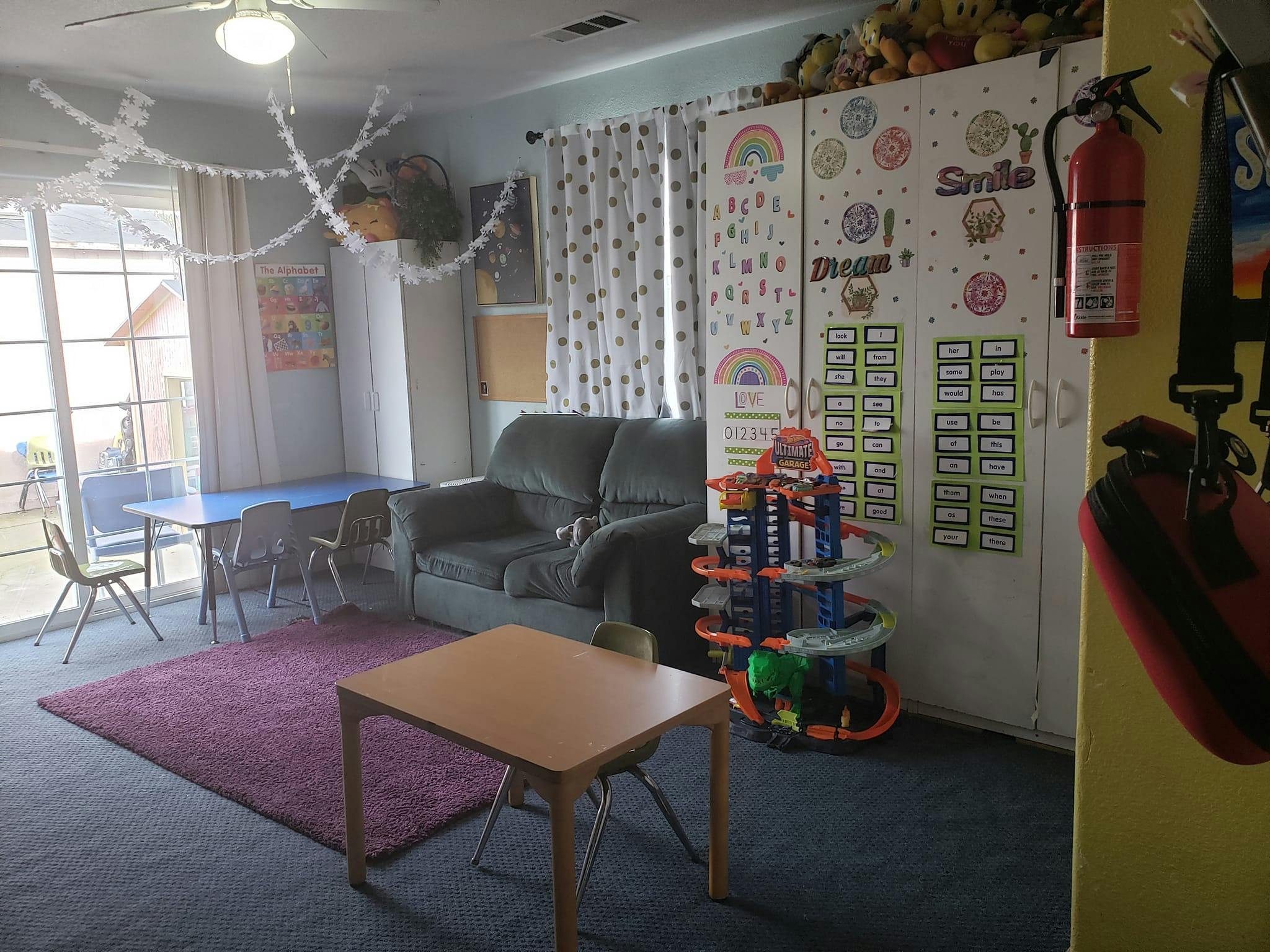 A room with a sofa, small tables, and a sliding glass door