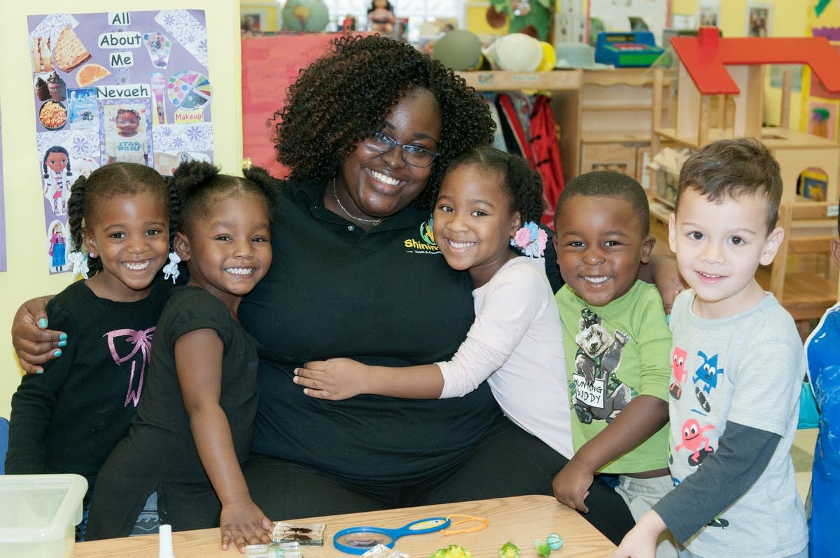Adult person with four children in a classroom
