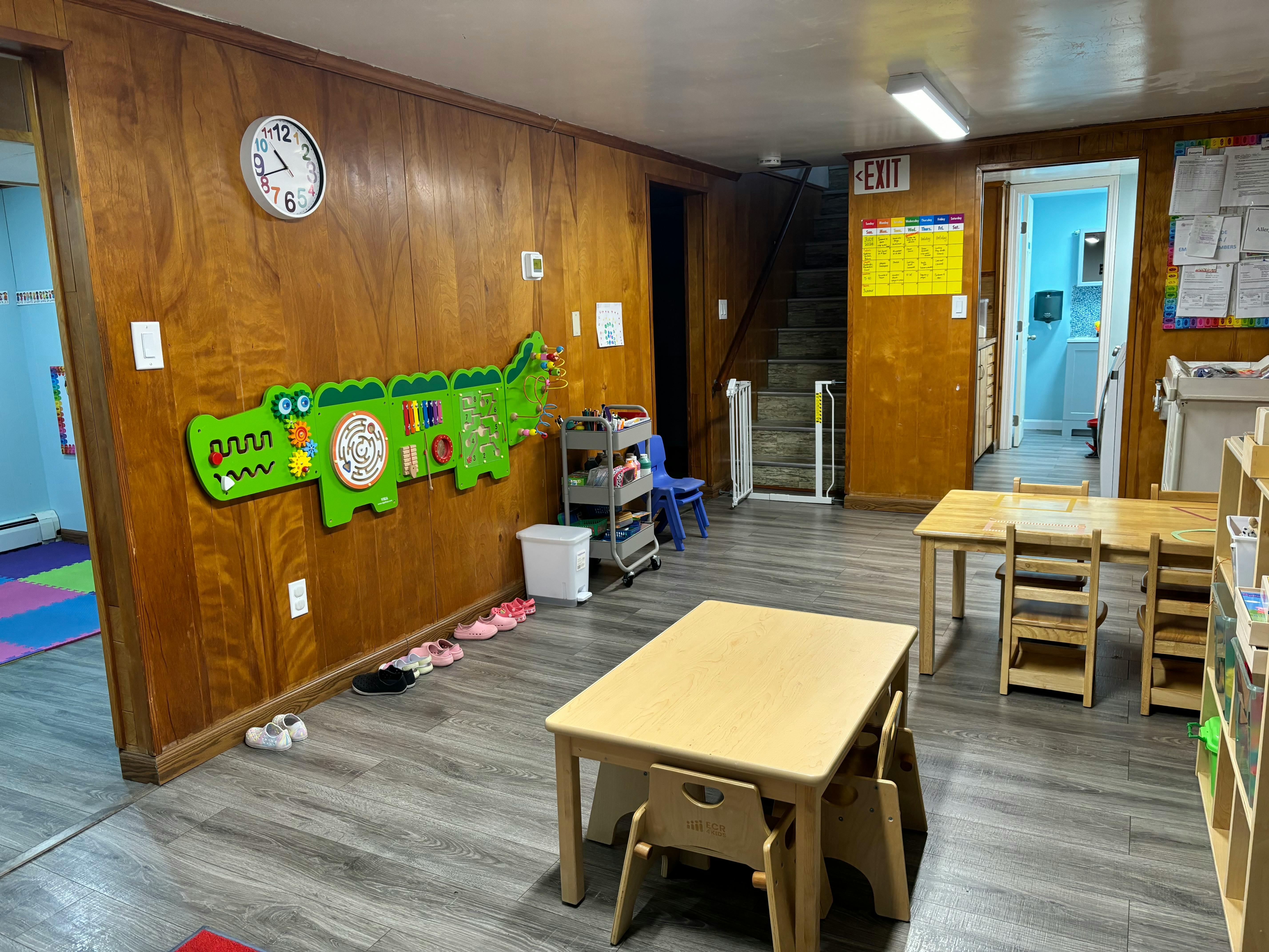 Playroom with small tables and chairs, a large alligator-shaped activity board