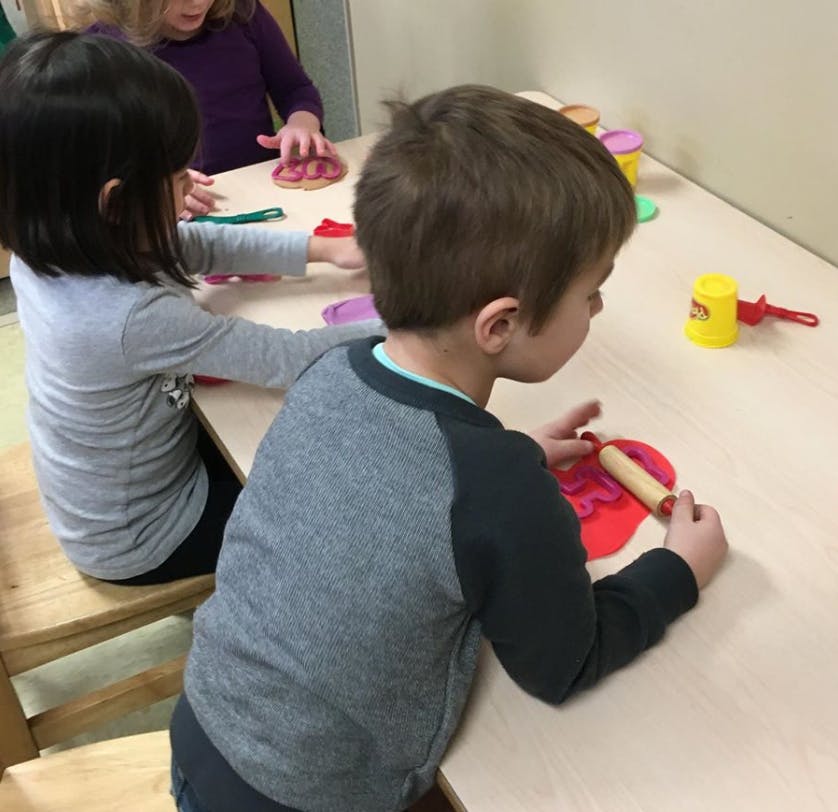 Children playing with modeling clay at a table