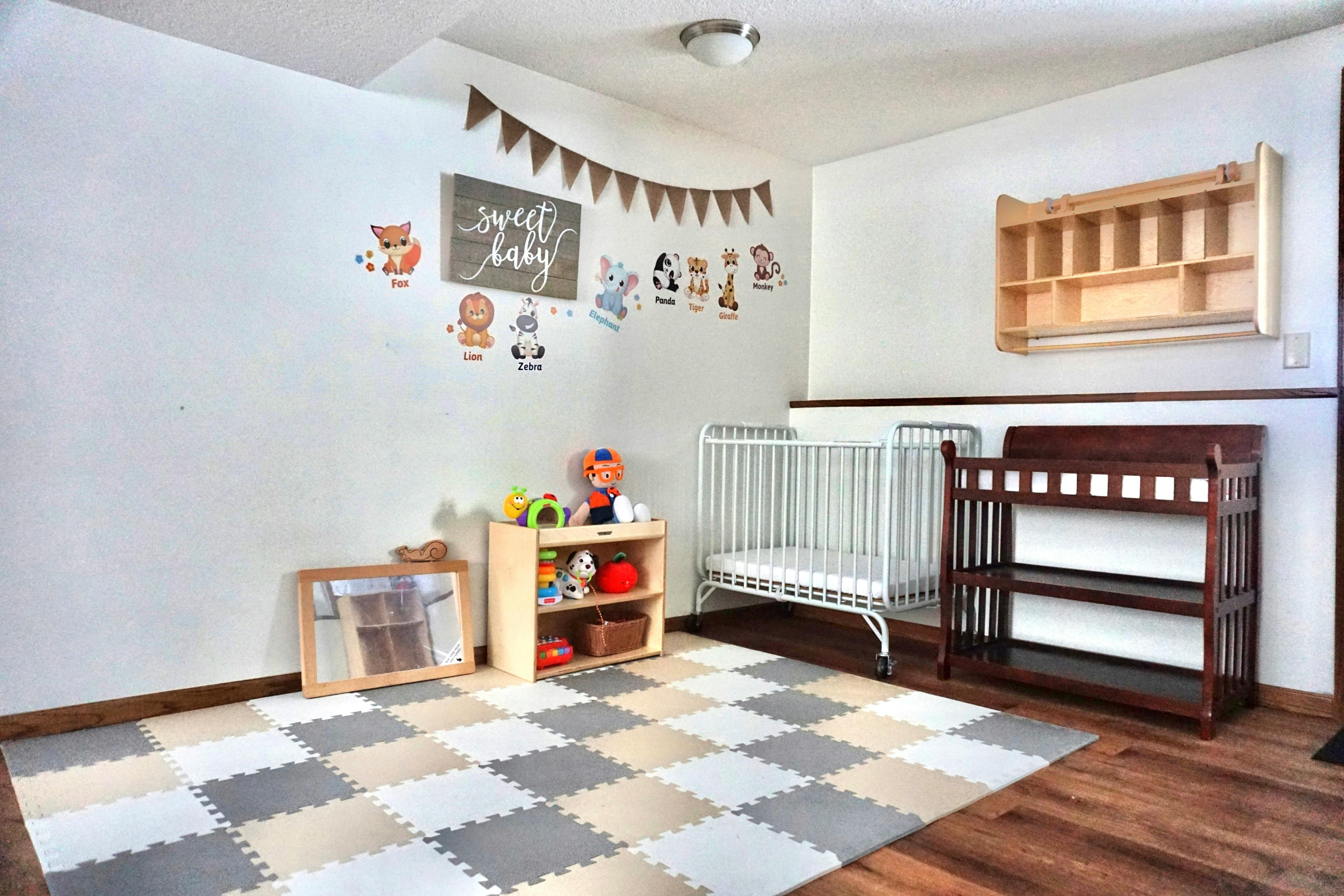 Baby room with a crib, changing table, and play mat on the floor