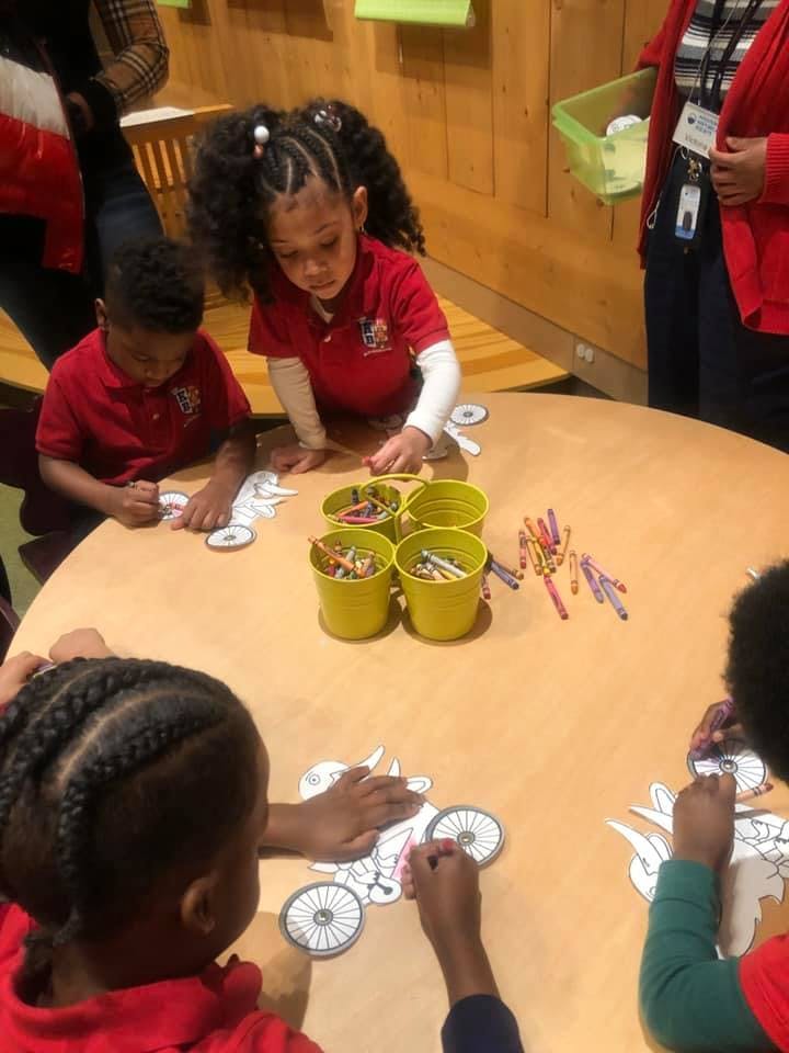 Children coloring at a round table with crayons