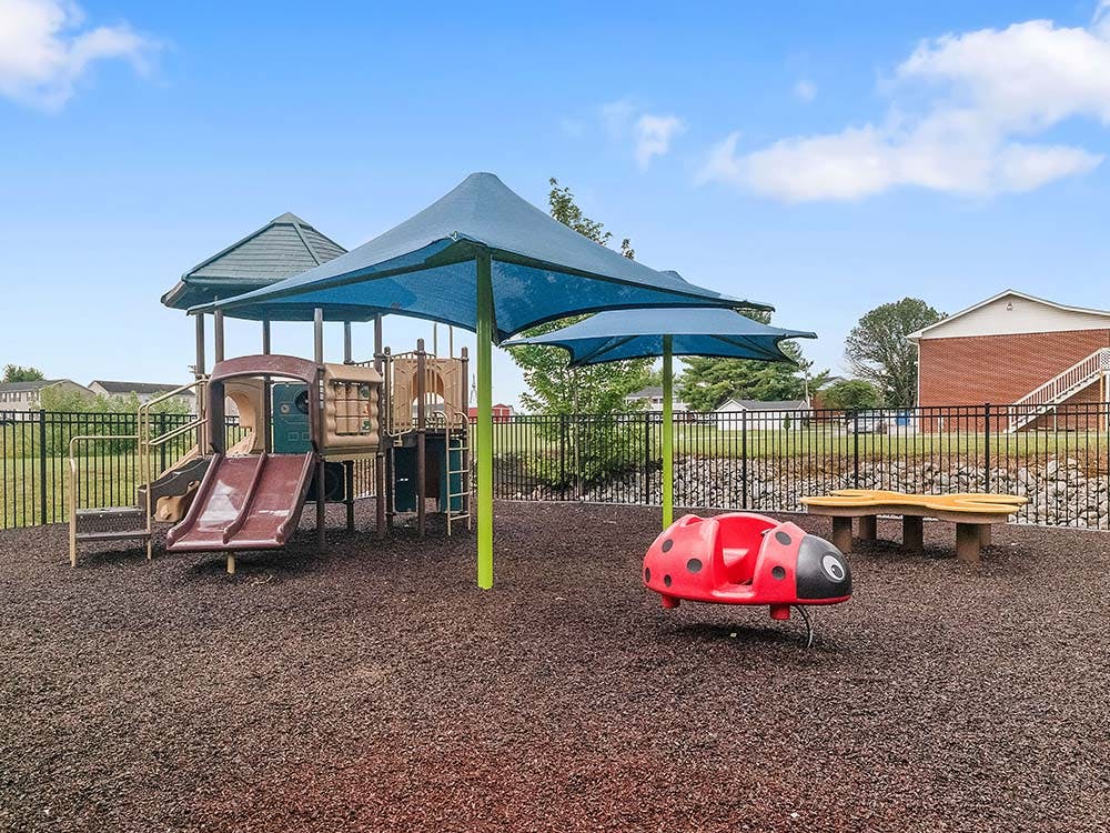 Playground with slides, climbing structures, and a ladybug spring rider