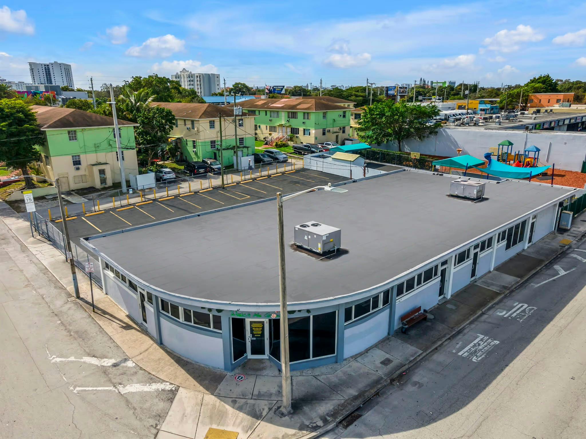 Aerial view of a commercial building with a curved facade and flat roof
