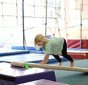 Child on hands and knees on a balance beam