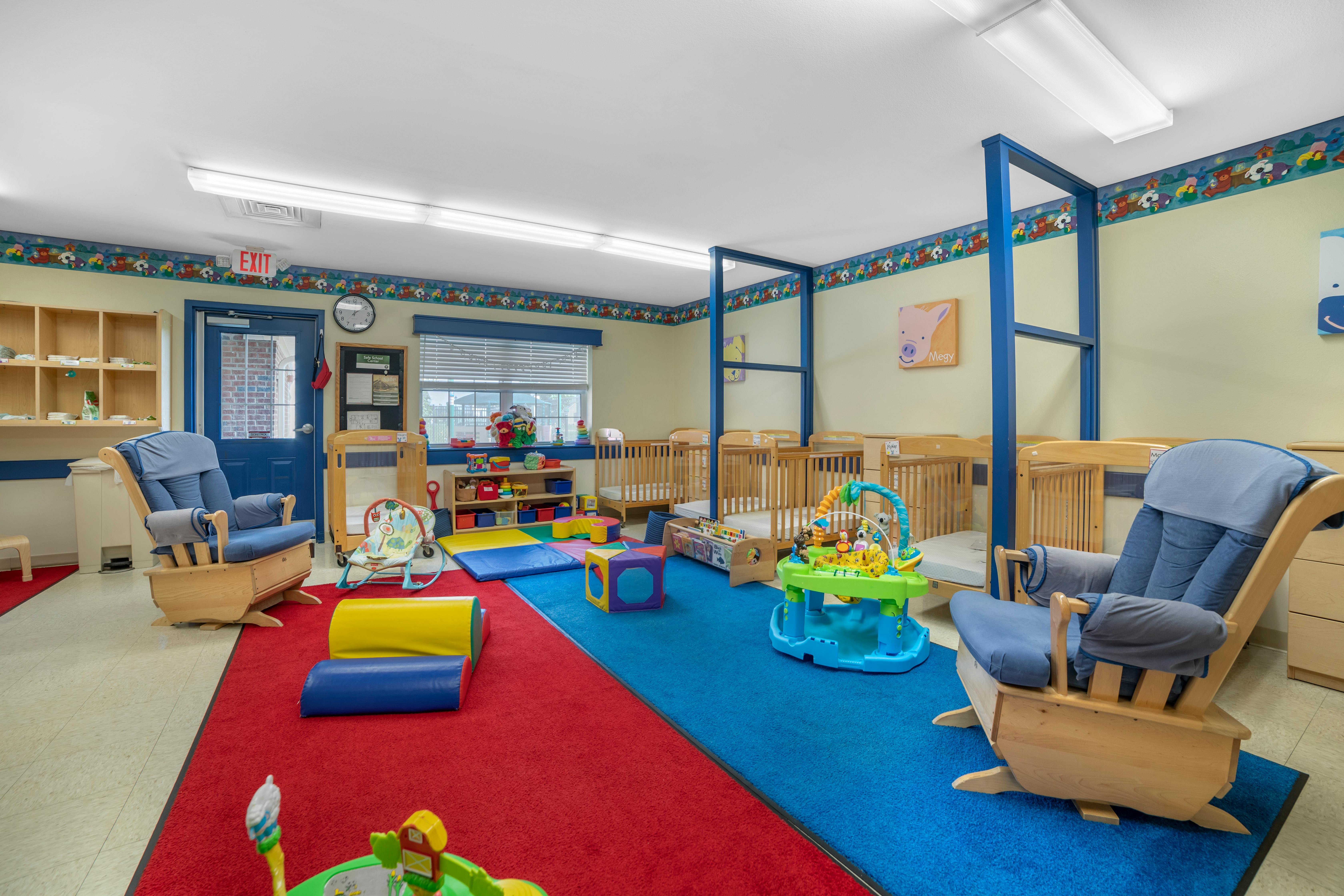 cribs in a daycare room with play mats and toys on the floor