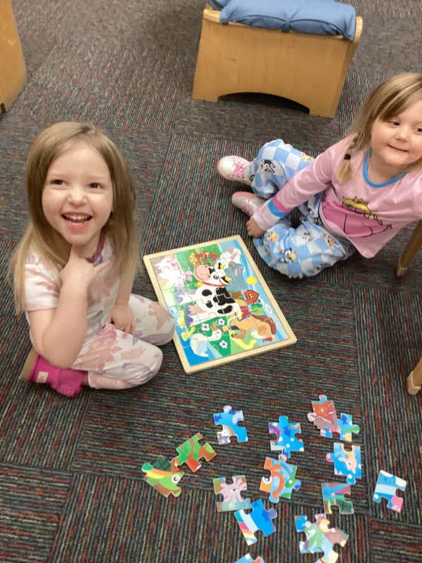 Two children on the floor with a puzzle
