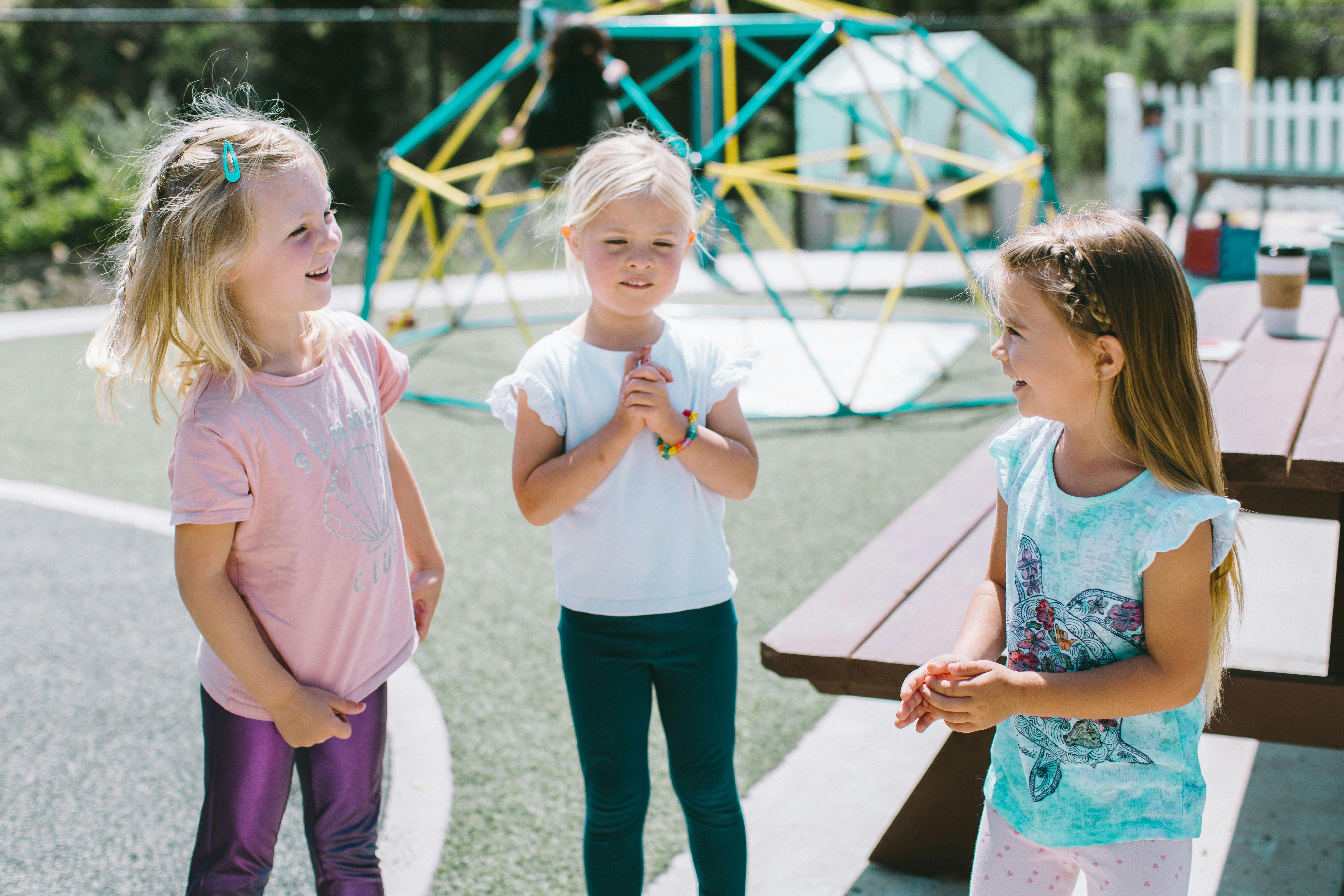 Three children standing on a playground